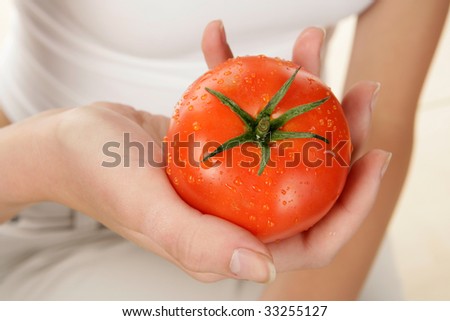 Woman hand with tomato