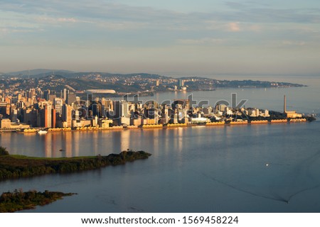 Aerial overview of Porto Alegre, Brazil. Beautiful sunset light illuminating the downtown skyline with reflection on Guaiba River water. Administrative building and football stadium visible. Foto stock © 