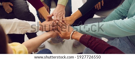 Positive friends stacking hands together