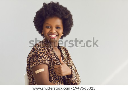 I'm okay. Portrait of happy female patient giving thumbs-up and showing arm with adhesive patch after getting Covid-19 vaccine. Vaccination, coronavirus immunity, safe travel concept. Space for text