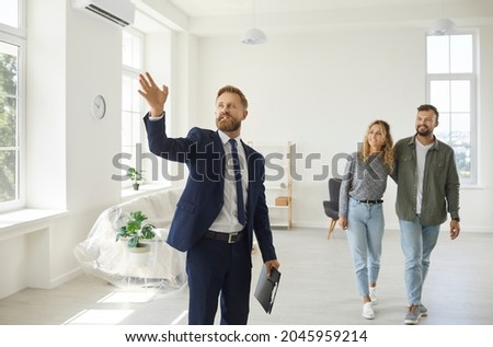 Real estate agent giving future tenants or first time buyers tour about modern spacious house. Boyfriend and girlfriend or husband and wife consider property investment, consult expert, buy new home Stockfoto © 
