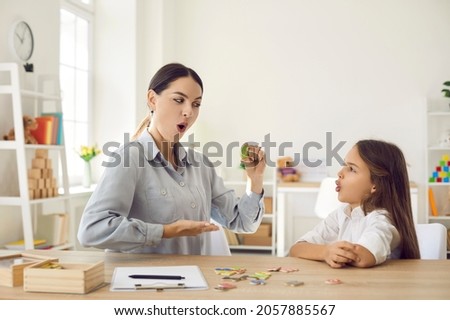 Female speech therapist curing child's problems and impediments. Happy kid together with homeschool mom or private English language tutor learning letter O, playing fun games and doing funny exercises Foto stock © 
