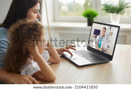 Healthy mother and child enjoying digital era, having online telemedicine consultation with remote doctor or watching educational video by professional paediatrician about cold and flu virus treatment Photo stock © 