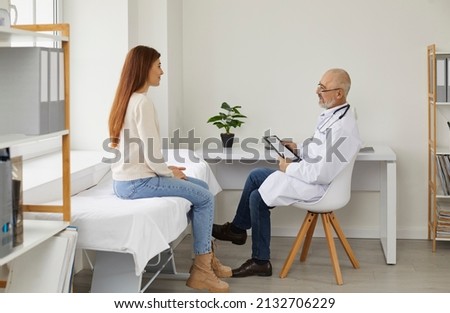 Old male doctor consult female patient in hospital. Senior man GP or therapist talk with woman client at appointment in private clinic. Good medical service. Healthcare and medicine. Сток-фото © 