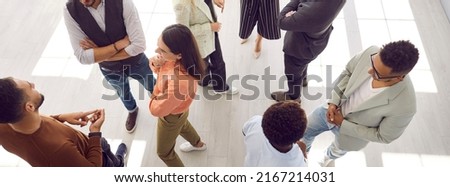 Young people meeting, interacting and making contacts at business event session. Group of multi ethnic participants standing in office and talking. High angle, overhead top view, above. Header, banner Foto d'archivio © 