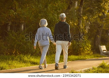 Similar – Image, Stock Photo Elderly couple walking a forest path along the seashore holding giant inflatable flamingo and unicorn. Funny active pensioners enjoying summer vacation on the beach in Northern Europe