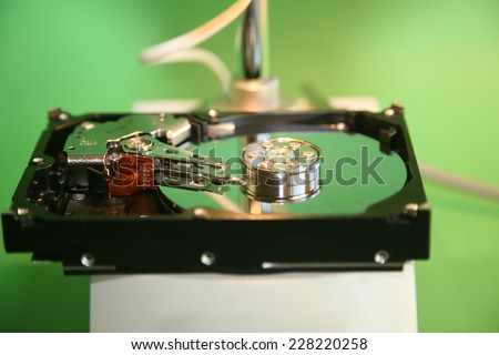 A skilled Computer Technician examines a Computer Hard Drive under a Microscope looking for flaws, scratches in the disc, and other issues to repair or replace. Computer Hard Drives are important
