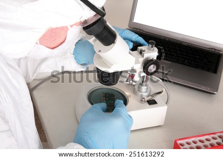 A Professional Computer Forensics Technician examines Computer Micro Chips under his microscope for microscopic damage and for information recovery of important and secret documents for clients.
