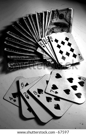 Royal Flush laying on a large pile of cash in $100.00 bills while a loosing hand lays next to it on a white background. \
\
in black and white for a special effect