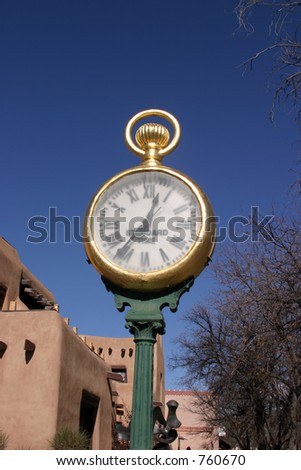 Old adobe building in New Mexico with a giant watch as a street clock