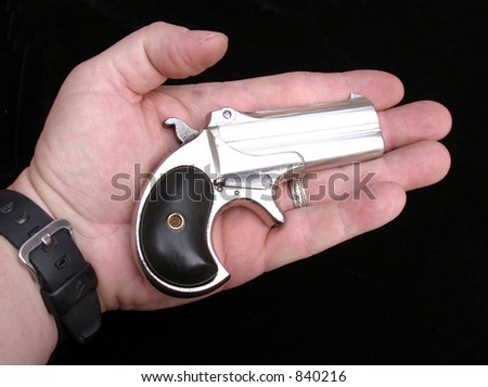 Circa 1889, Model 95, Type II Model 3 Double Derringer, in the palm of a mans hand showing the small size of the gun