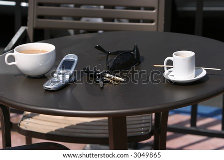 coffee and espresso with a cell phone, car keys, sun glasses outside