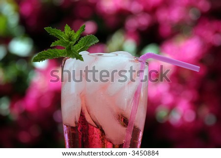cherry lemon lime soda outside with a sprig of mint a pink bendable straw with hot pink beauganvilla flowers in the background