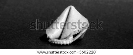a chinese fortune cookie with an Octopus Arm comming out for effect in black and white