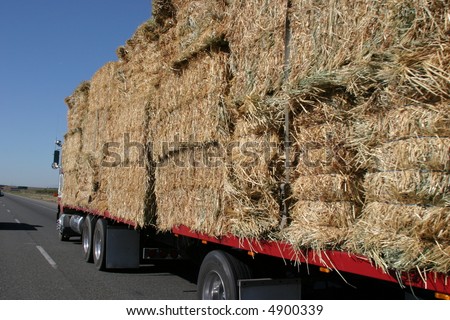 a semi truck hauling hay bails barrels down interstate 5 in northern california