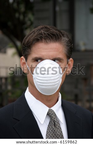 a business man wears a medical face mask or dust mask to protect himself and others from the flu and other airborn virus