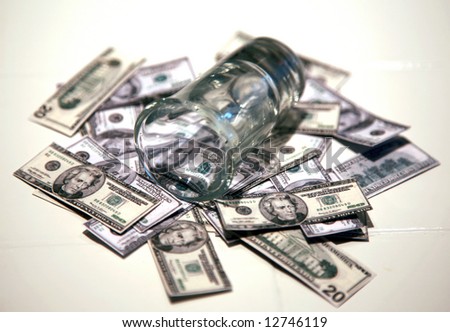 a shot glass lays upon a pile of miniature one hundred and twenty dollar bills, representing the high price of liquor and other economic slump concepts