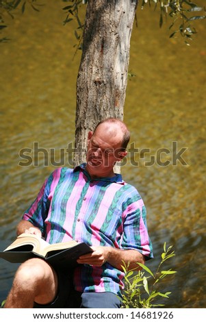 a man reads a book outside