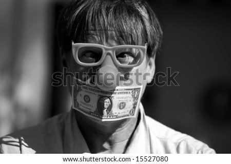 a man wears a rubber clown nose and glasses with a dollar bill taped over his mouth in protest against inflation and the rising cost of goods and services in black and white