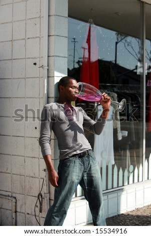 a male models relaxes with a Giant glass of wine after a hard day of modeling