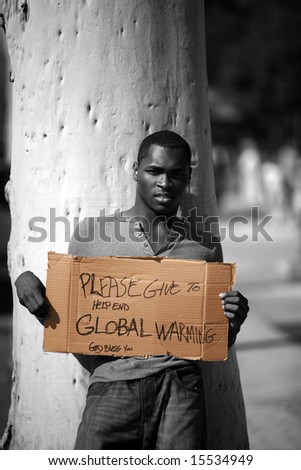 a man asks for donations to help stop Global Warming with his cardboard sign in black and white and colorized
