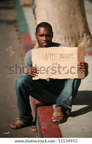 a male model holds a cardboard sign that reads 