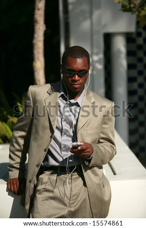 a well dressed Male Model listens to his personal digital music player