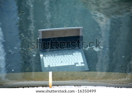 Computer damage concepts Laptop computer submerged in a pool of water
