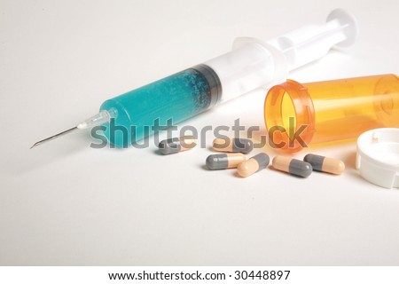 a hypodermic needle and pills  represents drug addiction, drug abuse, or medical concepts