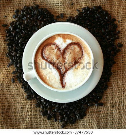 Coffee for Coffee Lovers, a cup of Coffee or  espresso with a Heart in the foam nestled in a bed of unground coffee beans on a burlap background