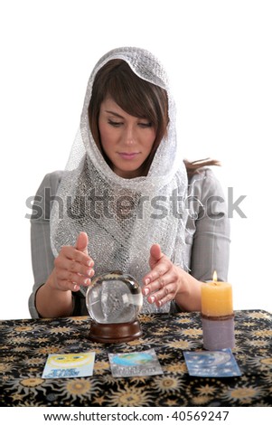 an attractive young fortune teller, looks into the future with her crystal ball, isolated on white,  with room for your text