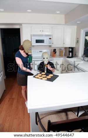 mother and son enjoy hot fresh baked cookies in their kitchen while wearing gas masks in the Future when Global Warming and CO2 have destroyed our way of living