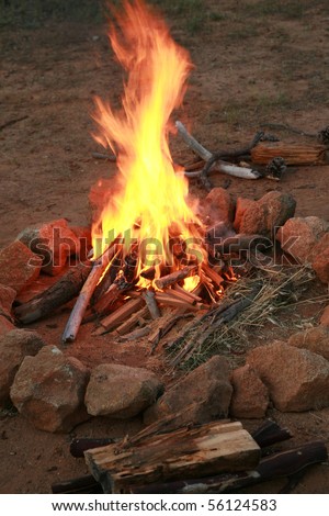 a camp fire in a fire pit at a campsite