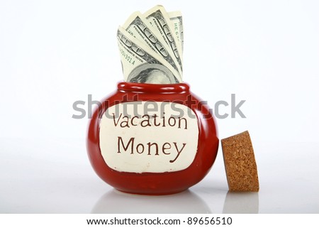 vacation money jar jam packed with cash isolated on white with room for your text