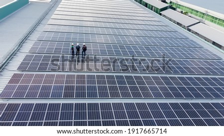 Solar panels installed on a roof of a large industrial building or a warehouse. Industrial buildings in the background. Horizontal photo. Сток-фото © 