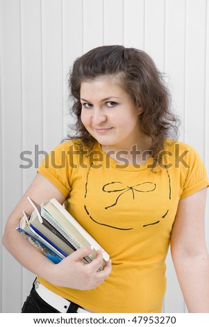 The young smiling girl with books and writing-books in hands