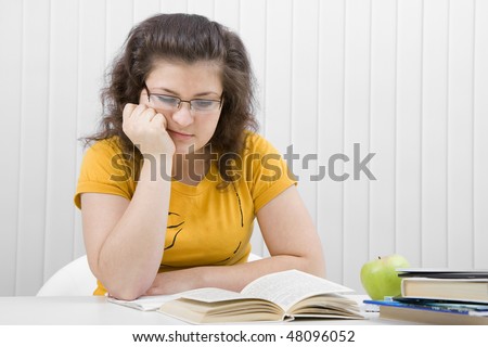 The girl the student sleeps on the book. Writing-books, apple and eyaglasses.