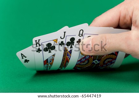 player\'s hand with the cards on the green game table