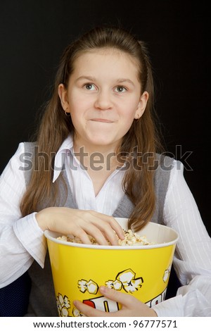 girl with popcorn on a black background