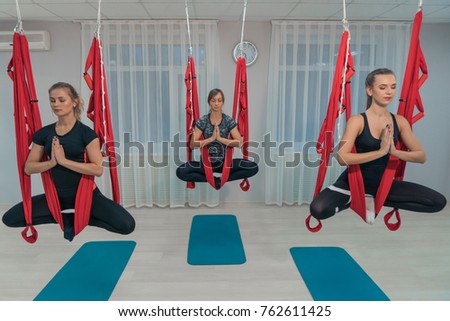 A group of young beautiful girls practicing flying yoga in a fitness room Imagine de stoc © 