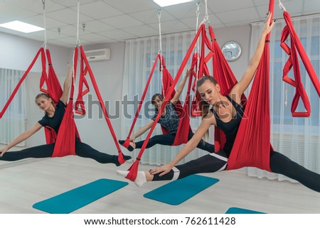 A group of young beautiful girls practicing flying yoga in a fitness room Imagine de stoc © 