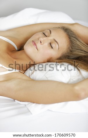 Beautiful young woman lying in bed.