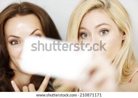 Two good friends having fun with a camera taking a selfie