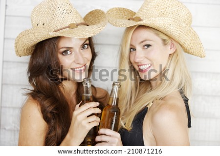 Two friends having fun in bikinis and summer hats