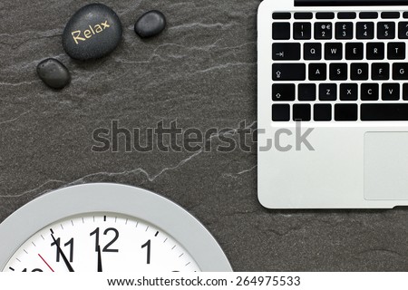 Office desk with laptop computer showing concept of appointment using clock face