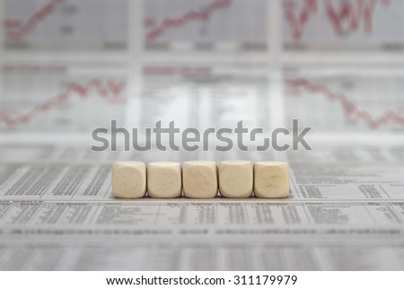 a row of five blank cubes on a business newspaper background