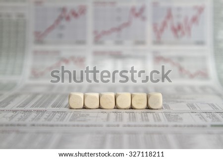 a row of six blank cubes on a business newspaper background