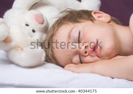 Sleeping boy and rabbit toy closeup