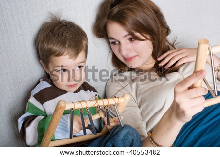 Boy and girl plays toy musical instrument indoor