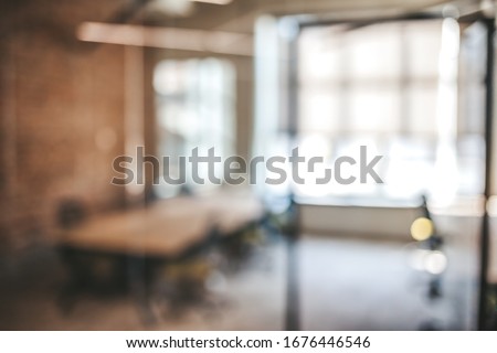 Blurred office interior space background. Blurred interior of modern office workplace a workspace design without partition decorate with black, white and wooden furniture